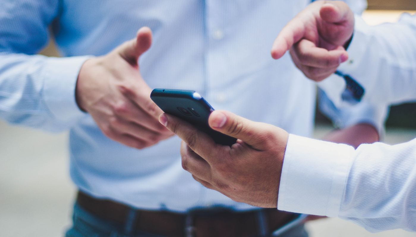 two men looking at smart phone